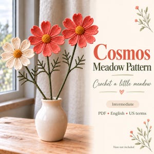 May include: Three crocheted cosmos flowers with coral and cream petals and yellow centres, featuring green stems and leaves, displayed in a white vase. The text reads: Cosmos Meadow Pattern, Crochet a little meadow, Intermediate, PDF, English, US terms, Vase not included.