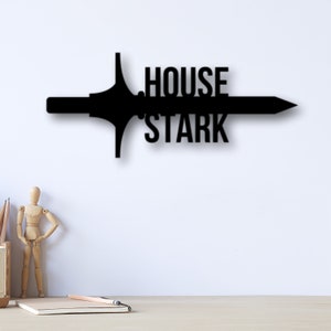 May include: Black metal wall decor featuring a stylized sword with the words "House Stark" in a bold font.