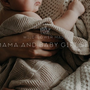 Peut inclure: Une couverture tricot&eacute;e beige enveloppant un b&eacute;b&eacute;, avec le texte WILDFLOWER MADE MAMA AND BABY GIFT SET. Le tissu pr&eacute;sente un motif tiss&eacute; textur&eacute; et le ton g&eacute;n&eacute;ral est neutre, mettant en valeur la mati&egrave;re en maille douce de la couverture.