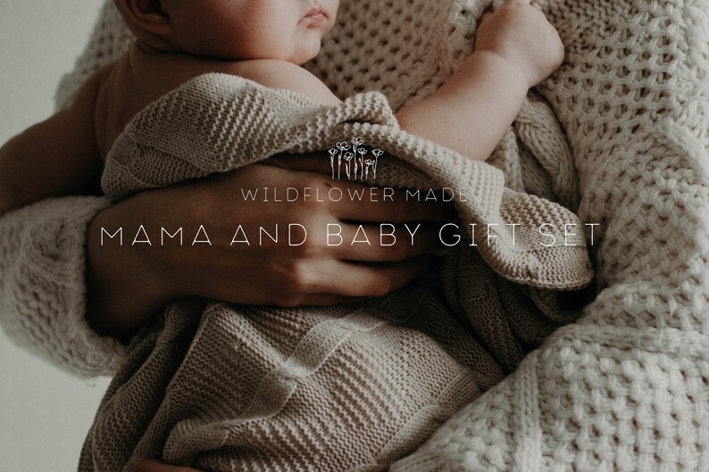 Peut inclure: Une couverture tricot&eacute;e beige enveloppant un b&eacute;b&eacute;, avec le texte WILDFLOWER MADE MAMA AND BABY GIFT SET. Le tissu pr&eacute;sente un motif tiss&eacute; textur&eacute; et le ton g&eacute;n&eacute;ral est neutre, mettant en valeur la mati&egrave;re en maille douce de la couverture.