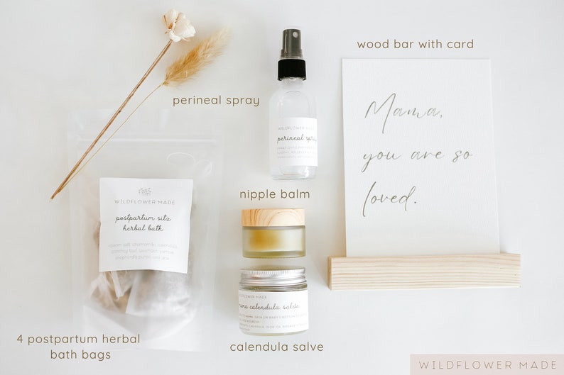 May include: A postpartum care set including four herbal bath bags in a clear pouch, a perineal spray in a clear bottle, a nipple balm in a glass jar with a wooden lid, a calendula salve in a glass jar, and a card reading Mama, you are so loved.