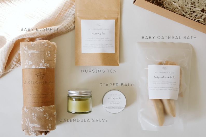 Peut inclure: Un coffret cadeau comprenant une couverture pour b&eacute;b&eacute; beige &agrave; motifs floraux, un sachet en papier brun de tisane d'allaitement, un petit pot en verre de baume au souci vert, une bo&icirc;te ronde de baume pour le change et un sachet de bain &agrave; l'avoine.