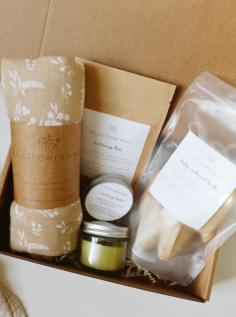 Peut inclure: Un coffret cadeau contenant une couverture en mousseline beige &agrave; motif floral blanc, un sachet de tisane d'allaitement Wildflower Made, un petit pot de baume d'allaitement, une bougie verte en pot de verre et un sachet de bain &agrave; l'avoine.