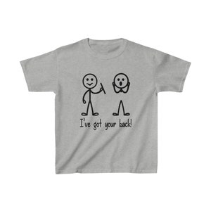 Può includere: Una maglietta grigia con un'illustrazione di due figure stilizzate. Una figura stilizzata tiene un'arma e l'altra è spaventata. Il testo "I've got your back!" è stampato sotto l'illustrazione.