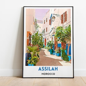 May include: A colorful illustration of a narrow street in Assilah, Morocco. The street is lined with white buildings with blue accents and lush green plants. The text "ASSILAH MOROCCO" is printed at the bottom of the image.