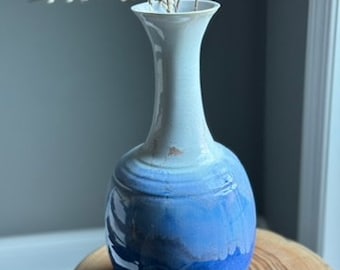 Handmade, wheel-thrown pottery, tall vase made of porcelain. It is a big statement piece in a flowing glaze of white into blue.