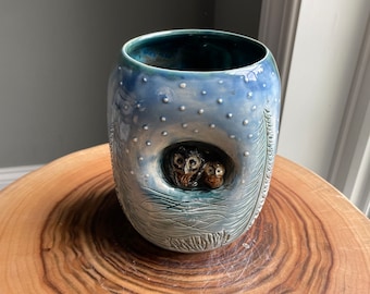 Cute vase with hand carved owls huddled in a tree in the snow. It is handmade and wheel thrown and glazed to look like nature.