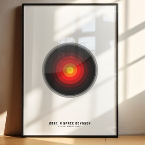 Könnte beinhalten: Ein minimalistisches Poster mit einem schwarzen und roten Kreisdesign. Der Kreis hat konzentrische Ringe in Rot, Orange und Gelb. Der Text "2001: ODYSSÉE IM WELTRAUM EIN FILM VON STANLEY KUBRICK" befindet sich am unteren Rand des Posters.
