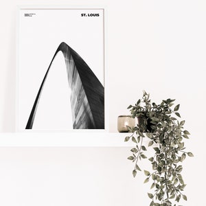 May include: A black and white photograph of the Gateway Arch in St. Louis, Missouri. The arch is a popular tourist destination and a symbol of the city.