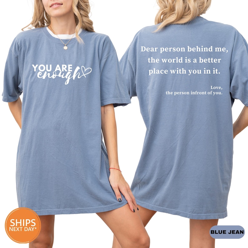 a woman wearing a blue shirt that says you are enough