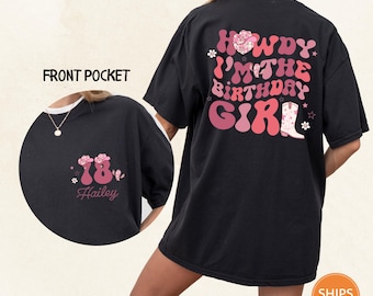 May include: Black t-shirt with a retro design. The back features the text "Howdy I'm the Birthday Girl" in pink and red, with a cowboy boot graphic. The front pocket has a floral design with the number "78" and the name "Hailey".