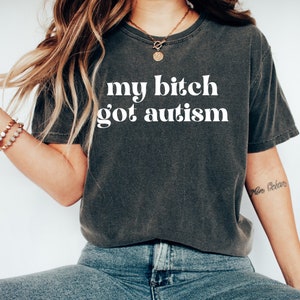a woman wearing a t - shirt that says, my bitch got autism