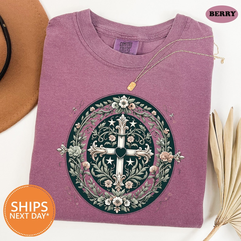 a purple t - shirt with a cross on it