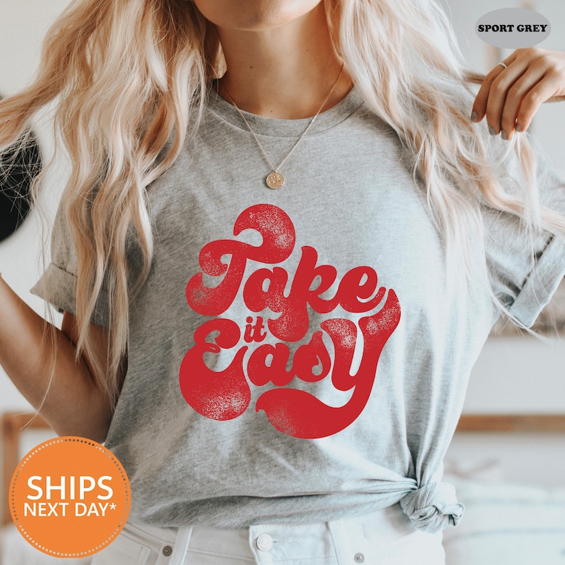 a woman wearing a grey shirt that says fake is easy