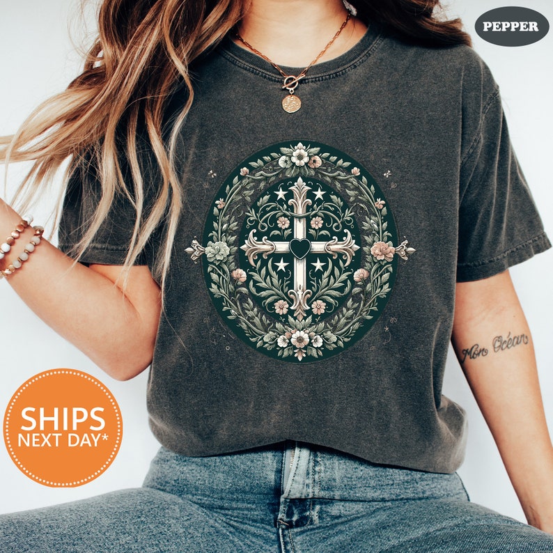 a woman wearing a t - shirt with a cross on it