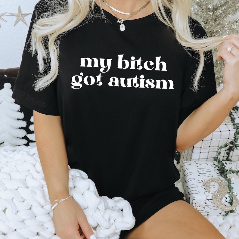 a woman wearing a black shirt that says, my bitch got autism