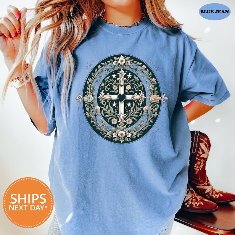 a woman wearing a blue shirt with a cross on it