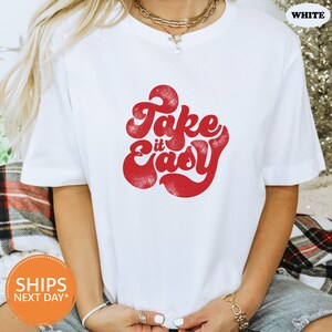 a woman wearing a white t - shirt that says fake is easy