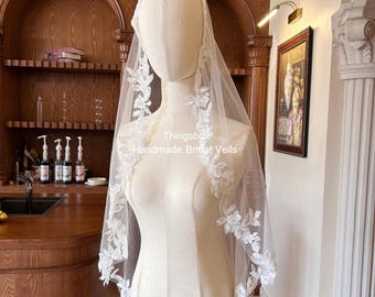 Véu de noiva estilo mantilha com renda floral em formato de folha e contas, com pente, acabamento em renda de folhas, véu até a altura dos dedos.