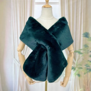 May include: A dark green faux fur shawl with a V-neckline. The shawl is draped over a mannequin.