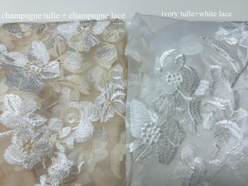 May include: Two swatches of tulle fabric with floral embroidery. The left swatch is champagne tulle with champagne lace. The right swatch is ivory tulle with white lace.