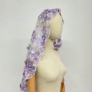 May include: A delicate, sheer lilac veil with embroidered purple flowers. The veil is scalloped and has a floral design.