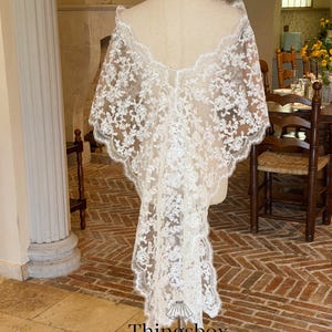May include: A white, floral lace bridal veil displayed on a mannequin. The veil has a scalloped edge and a long, flowing design. The text "Thingsbox Handmade Bridal Veils" is visible at the bottom.