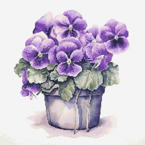 Op de afbeelding: Een boeket paarse viooltjes in een blauwe pot met groene bladeren. De viooltjes bloeien en hebben een wit hart.