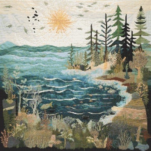May include: A cross-stitch embroidery depicting a serene lakeside scene with a sun shining brightly in the sky, a forest of pine trees on the right side of the image, and a blue lake with waves and fish in the foreground.
