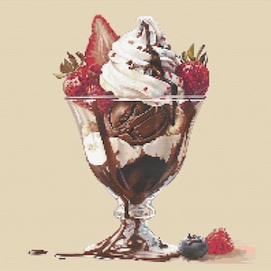 Puede incluir: Un bol de vidrio lleno de helado de chocolate, crema batida, salsa de chocolate y fresas y frambuesas frescas. El bol está sobre un fondo blanco y tiene un chorrito de salsa de chocolate.