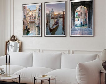 Può includere: Un set di tre stampe artistiche da parete verticali incorniciate che raffigurano scene di Venezia, Italia. Le immagini mostrano gondole che navigano in canali stretti, edifici storici con facciate color pastello e una vista attraverso un arco in pietra.