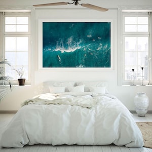a bedroom with a large painting hanging above the bed