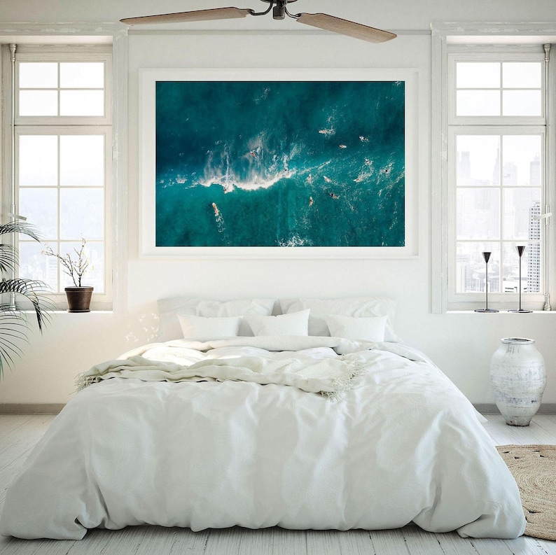 a bedroom with a large painting hanging above the bed