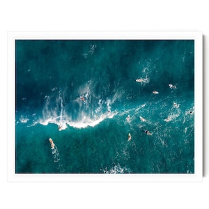 a group of surfers riding the waves in the ocean, with their surfboards visible beneath them.