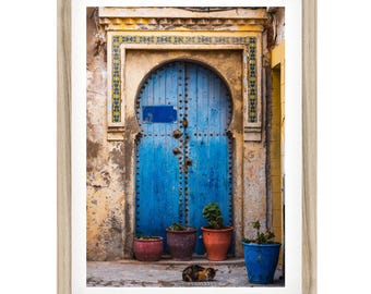 Niebieskie drzwi i nadruk z kotem, marokańska sztuka ścienna, fotografia vintage z Maroka