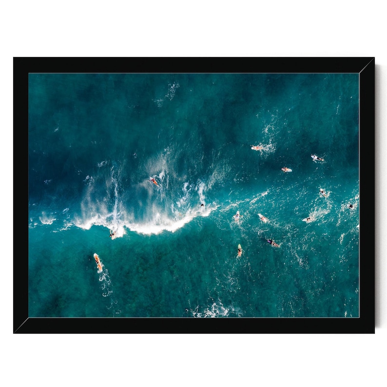 a group of people surfing in the ocean, with waves crashing around them.
