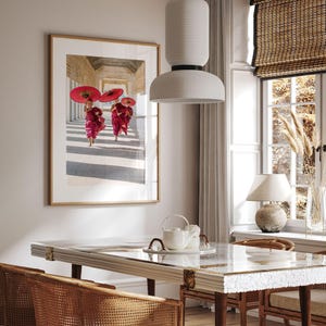 a picture of two women with umbrellas hanging above a table