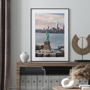 a framed photograph of the Statue of Liberty in New York City, with the city skyline in the background.