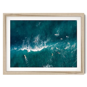 an aerial view of surfers riding a wave in the ocean