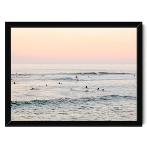 a group of people enjoying themselves in the ocean, with some of them riding waves on surfboards.