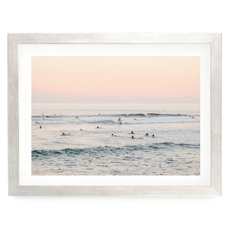 a group of people enjoying themselves in the ocean, with some of them riding waves on surfboards.