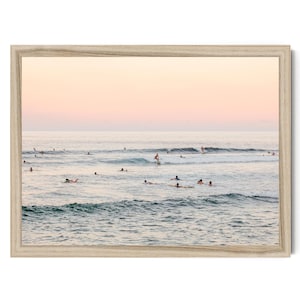 a group of people enjoying themselves in the ocean, with some swimming and others surfing on the waves.
