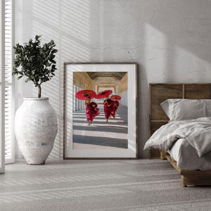 a picture of two red umbrellas hanging on a wall
