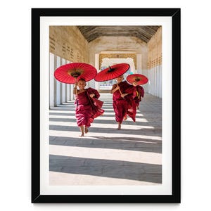 two women with red umbrellas walking down a hallway
