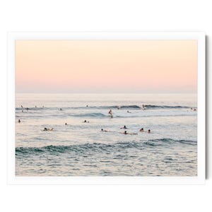 a group of people enjoying themselves in the ocean, with some of them surfing on the waves.