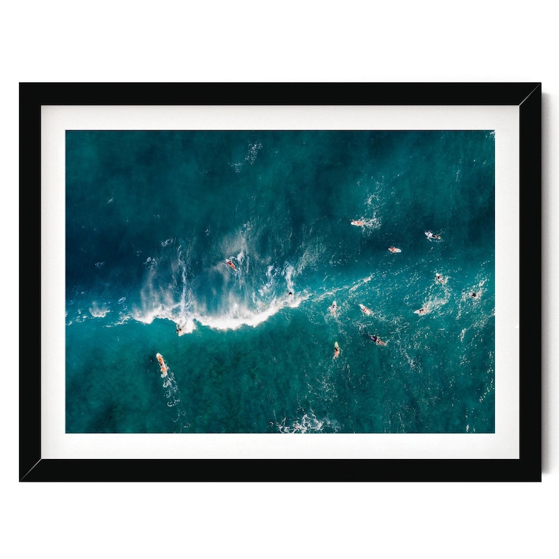 an aerial view of surfers riding a wave in the ocean