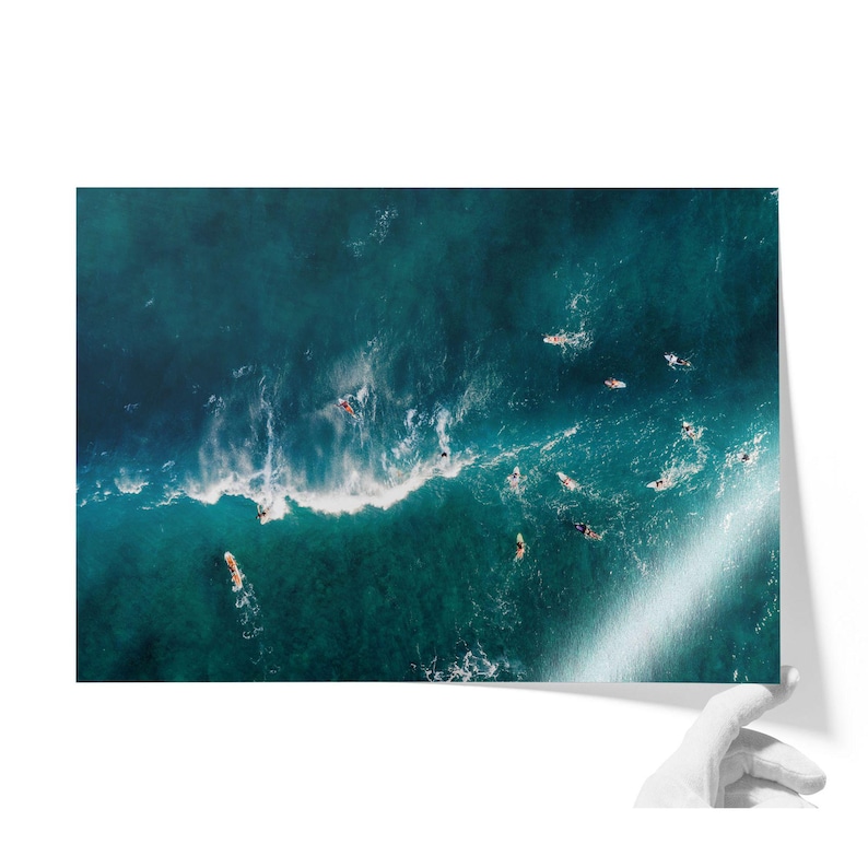 an aerial view of surfers in the ocean