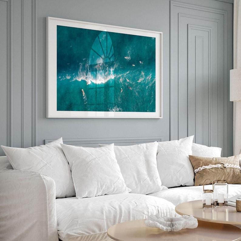 a living room with a white couch and a painting on the wall