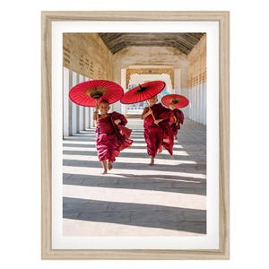 two women with red umbrellas walking down a hallway