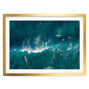 a group of people surfing on a large, turquoise ocean wave.